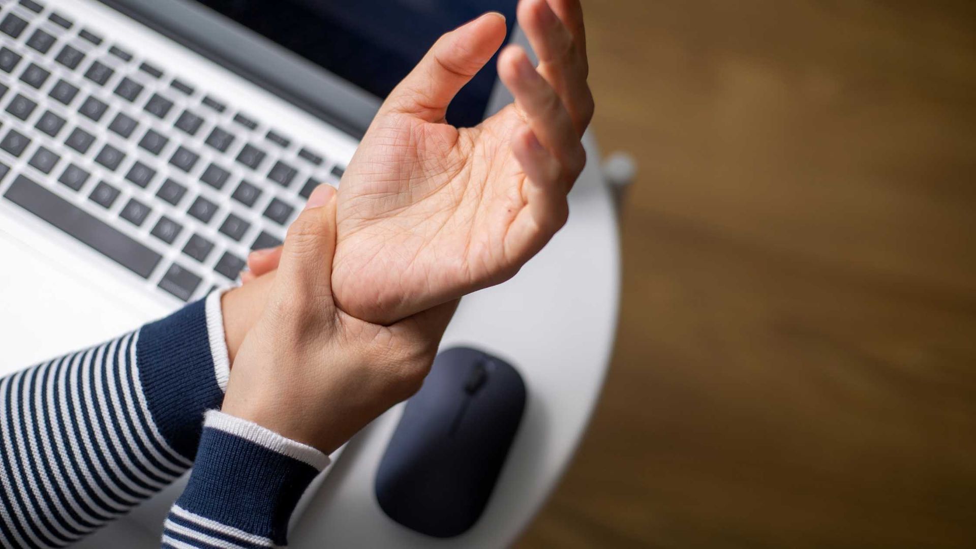 A person with wrist pain caused by using non-ergonomic equipment